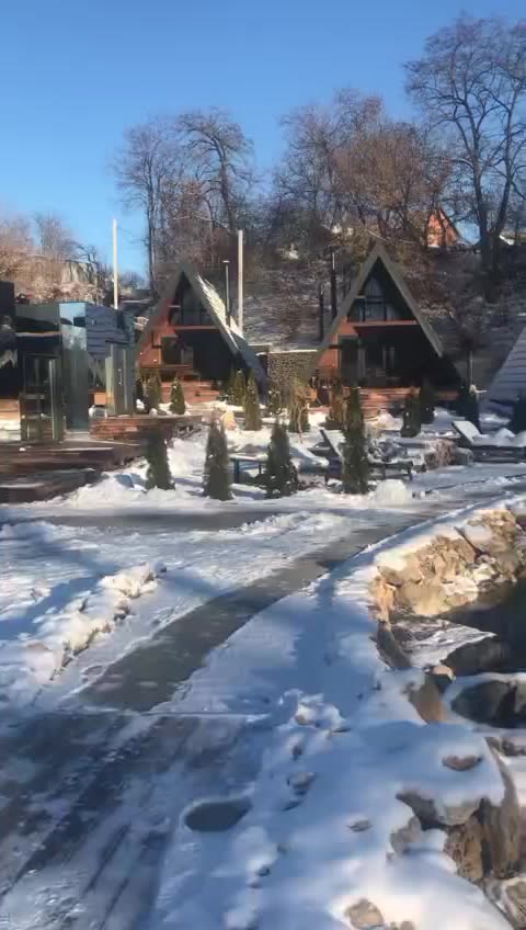 Кілька А-фреймів бази відпочинку поруч, засніжена територія